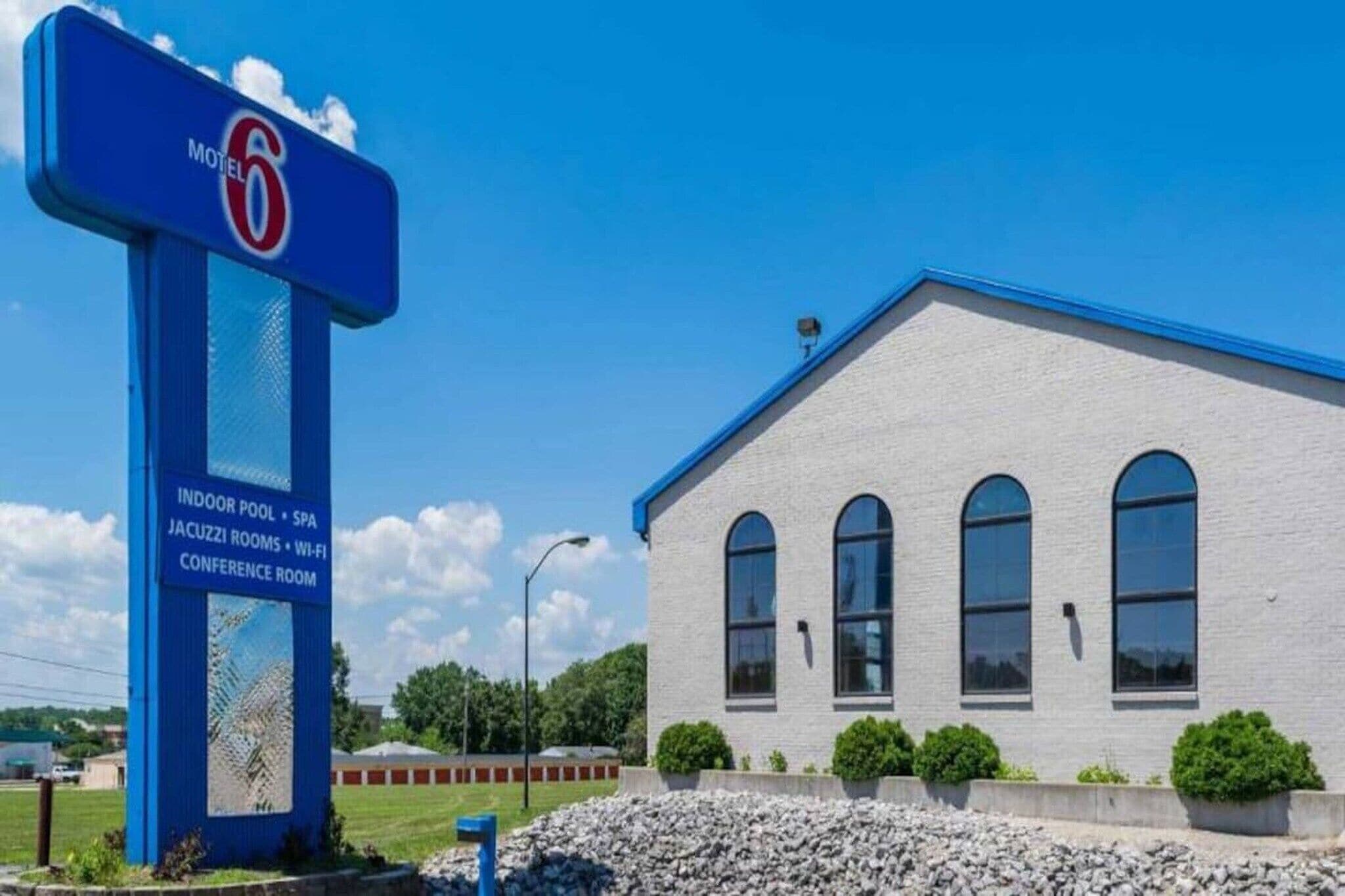 Un edificio con el letrero de Motel 6, que ofrece servicios como piscina cubierta, spa, sala de hidromasaje, Wi-Fi y una sala de conferencias.