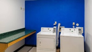 Een wasserette met twee voorladers, een groen aanrecht en een blauwe muur.