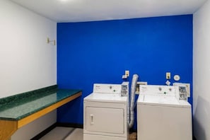 A laundry room with two front-loading washing machines, a green countertop, and a blue wall. - 1 King Bed | Non-Smoking (Richmond IN)