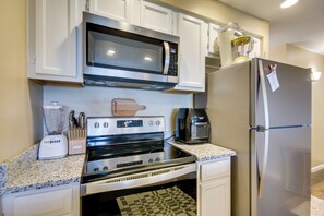 A compact kitchen with a microwave, stove, refrigerator, and coffee maker. - 'The Wake Zone' Condo Near Lake of the Ozarks (Lake Ozark)