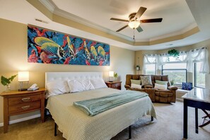 A bedroom with a large bed, a ceiling fan, a painting, and a view of the outdoors. - 'The Wake Zone' Condo Near Lake of the Ozarks (Lake Ozark)