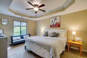 A bedroom with a bed, a nightstand, a desk, a chair, a ceiling fan, and a window with blinds. - 'The Wake Zone' Condo Near Lake of the Ozarks (Lake Ozark)