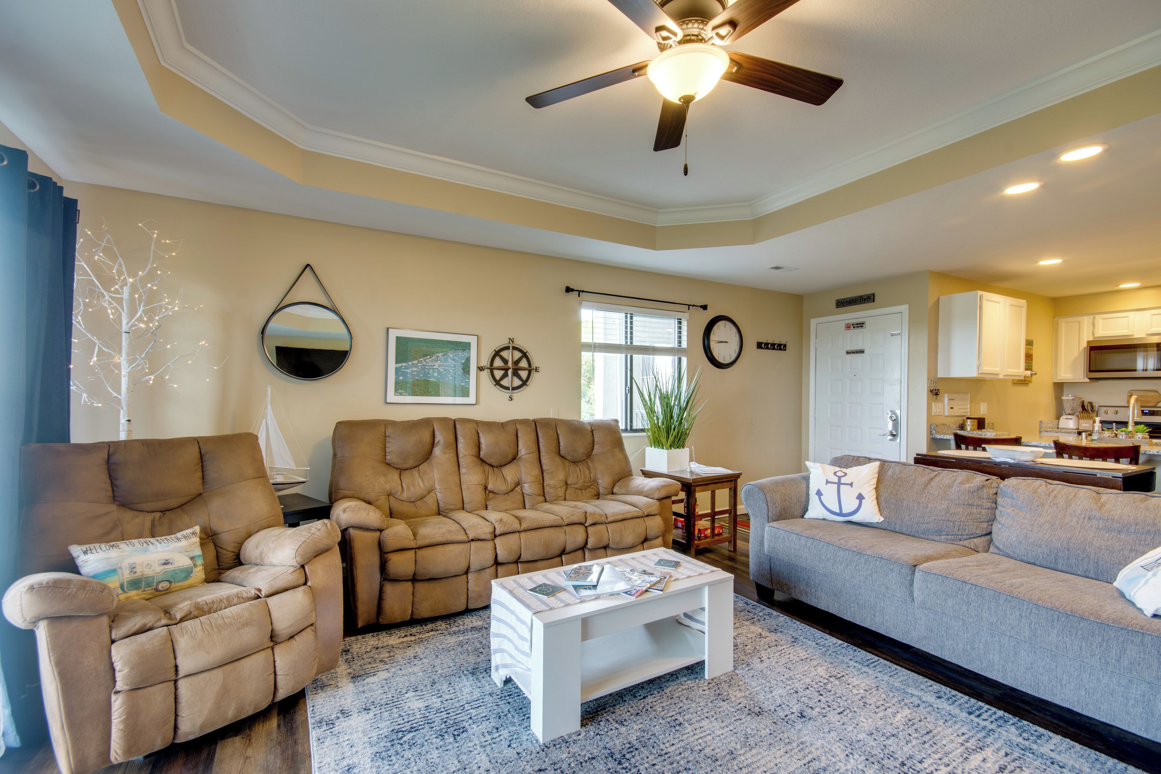 A living room with a ceiling fan, a coffee table, and two sofas.