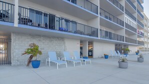 A multi-story building with balconies, outdoor seating, and potted plants. - Unit w/ Stunning Gulf Views! Steps to Pool & Beach (Madeira Beach)