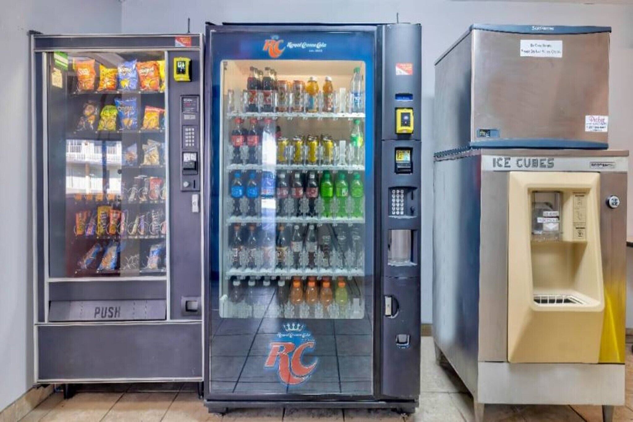 Three vending machines with various items, including snacks and beverages.