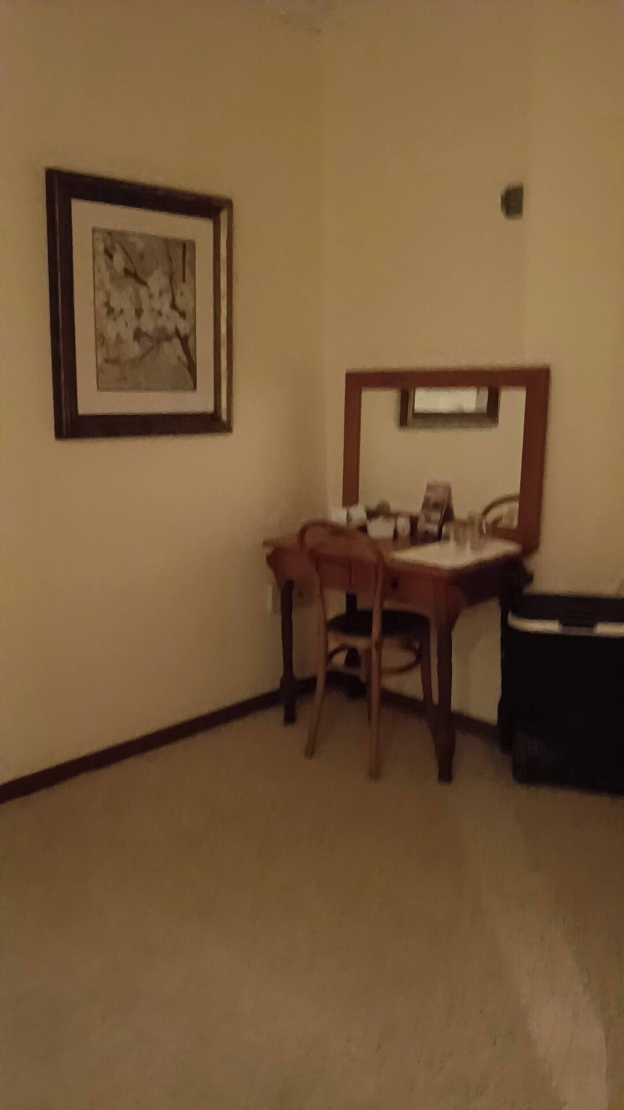 Une pièce comprenant un bureau, une chaise et un tableau encadré accroché au mur.