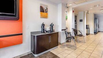 A reception area with a counter, chairs, and a television.