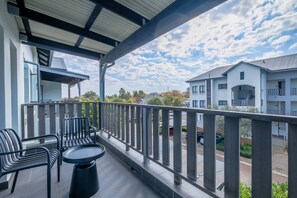 A balcony with a table and chairs, a covered area, and a view of a residential building. - Modern, Peaceful Stay in Broadacres (Chartwell)