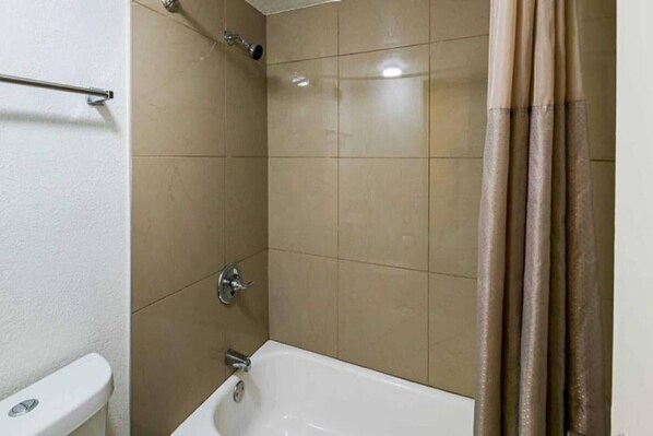 A bathroom with a bathtub, a shower, and a toilet. - 1 KING BED | SUITE NON-SMOKING (Grand Prairie)