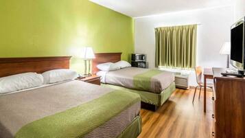 A hotel room with two beds, a desk, a chair, a television, and a window with curtains.