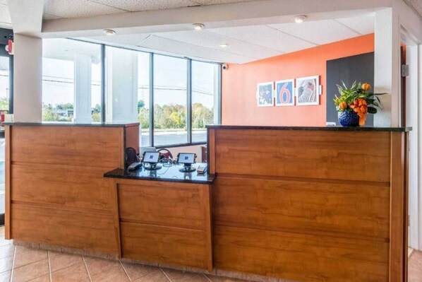 A reception desk with a computer, a telephone, and a small plant.