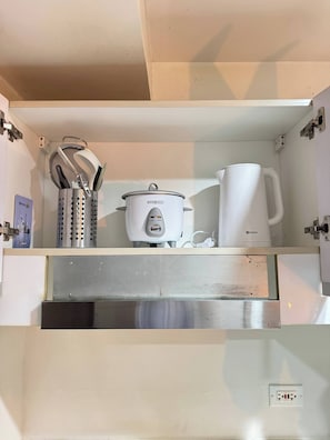 A kitchen with a built-in oven, a coffee maker, and a pot on the countertop. - Fully Furnished Makati Condo with FAST Wi-Fi and Queen Bed (Makati City)