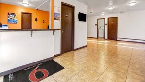 A hotel reception area with a reception desk, a clock, and a 'Welcome' mat. - 2 Queen Beds | Non-Smoking, Micfridge (Silver City NM)