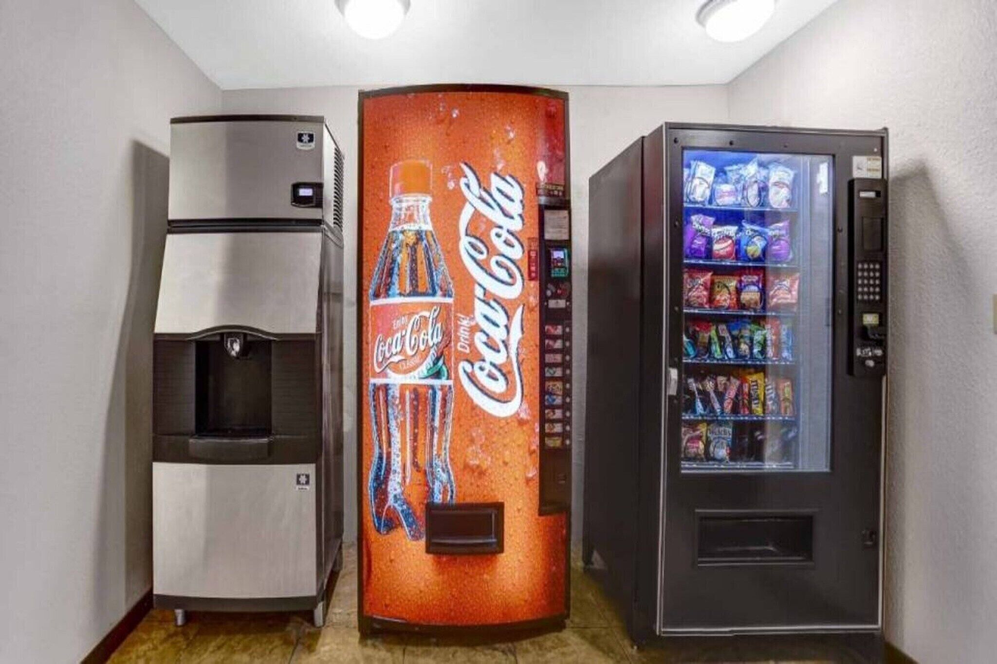 A vending machine with a Coca-Cola logo, a beverage dispenser, and a snack vending machine.