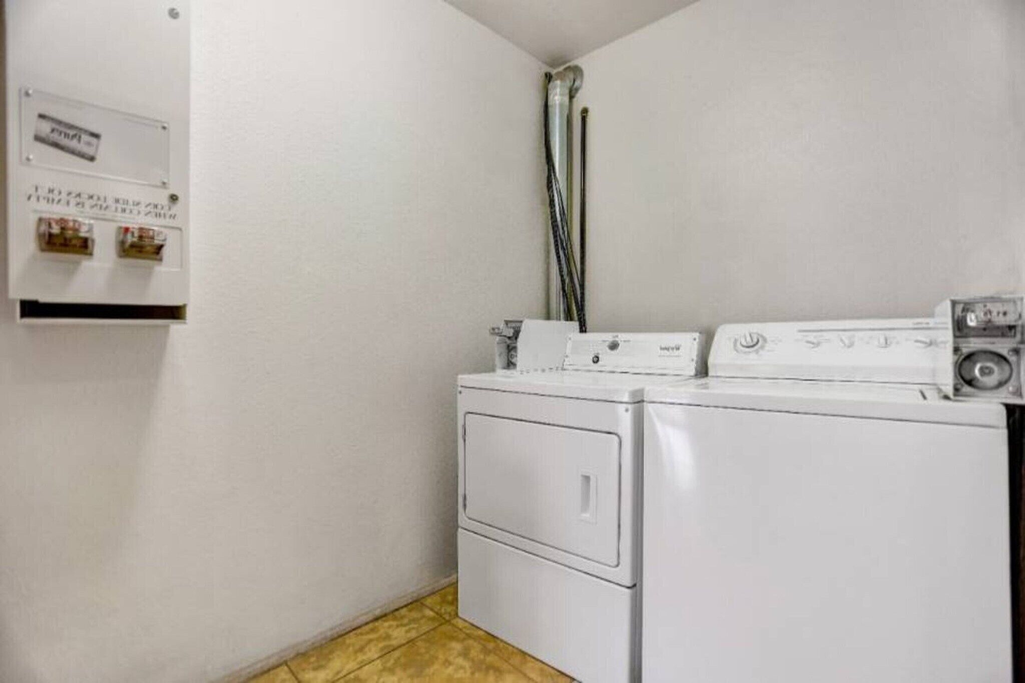 A laundry room with a washing machine and dryer, a utility meter, and a water heater.