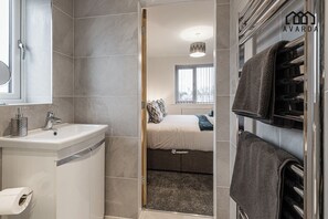 A modern bathroom with a sink, toilet, and towel rack. - 7 Tannery House | Wi-Fi | Parking | Contractors (Freckleton)