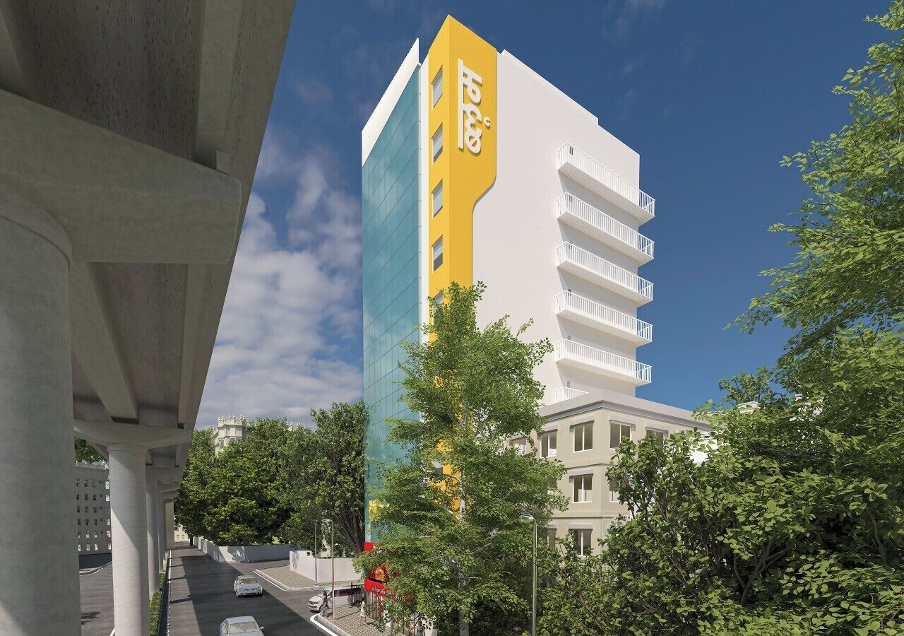 A multi-story building with a prominent yellow vertical element and a white facade.