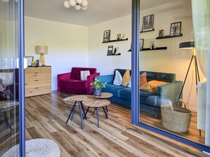Una sala de estar moderna con un sofá, un sillón, una mesita de centro y una lámpara.
