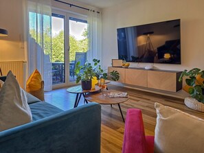 Ein modernes Wohnzimmer mit einer Couch, einem Couchtisch und einem an der Wand befestigten Flachbildfernseher.