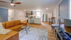 A spacious living room with a leather sofa, a coffee table, and a TV stand. - Quiet Country Living Near Whiteville (Whiteville)