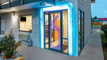 Een modern gebouw met een bord voor registratieparkeren, een symbool voor rolstoeltoegankelijkheid en het nummer 3050 op de gevel.