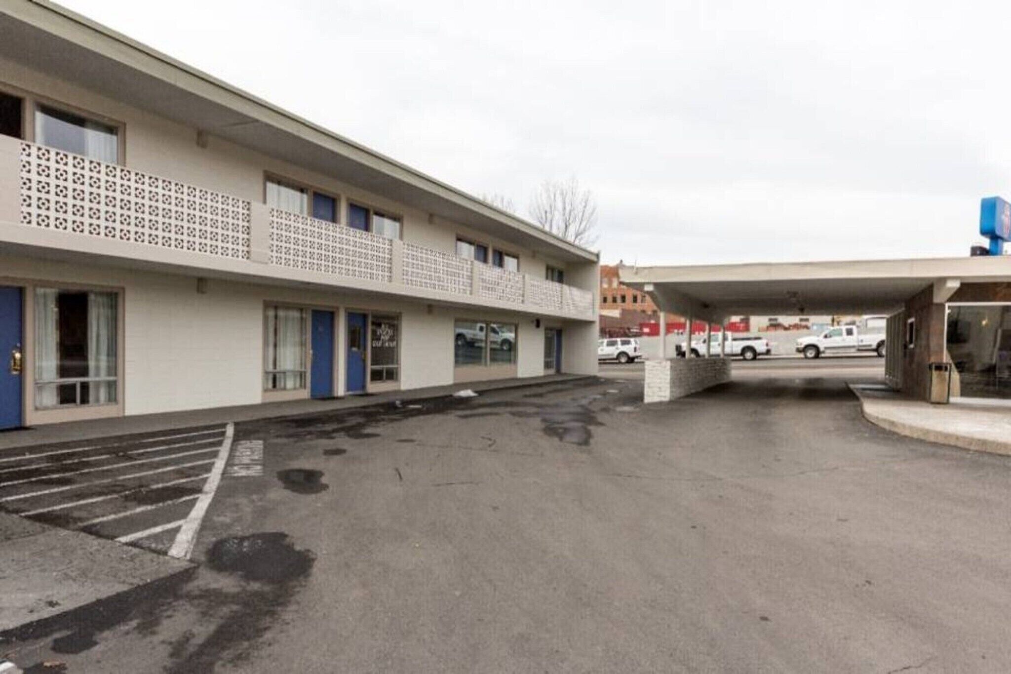 A multi-story hotel with a parking lot in front.
