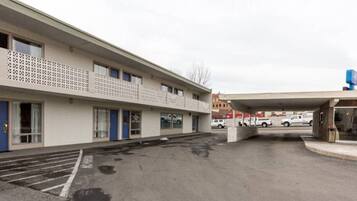 A multi-story hotel with a parking lot in front.
