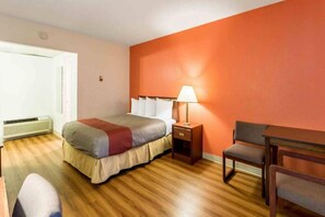 A hotel room with a bed, bedside table, lamp, and a chair. - 1 King Bed | Suite, Non-Smoking, Kitchen (Butte)