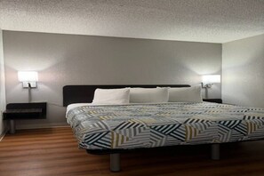 A hotel room with a bed, two bedside tables, and a nightstand. - 1 Queen Bed | Non-Smoking (Butte)