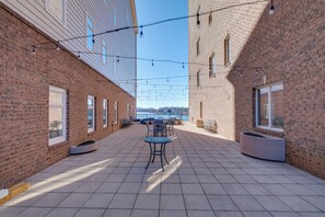 Eine Außenpatio-Terrasse mit Ziegelmauern, Sitzgelegenheiten und Lichterketten.