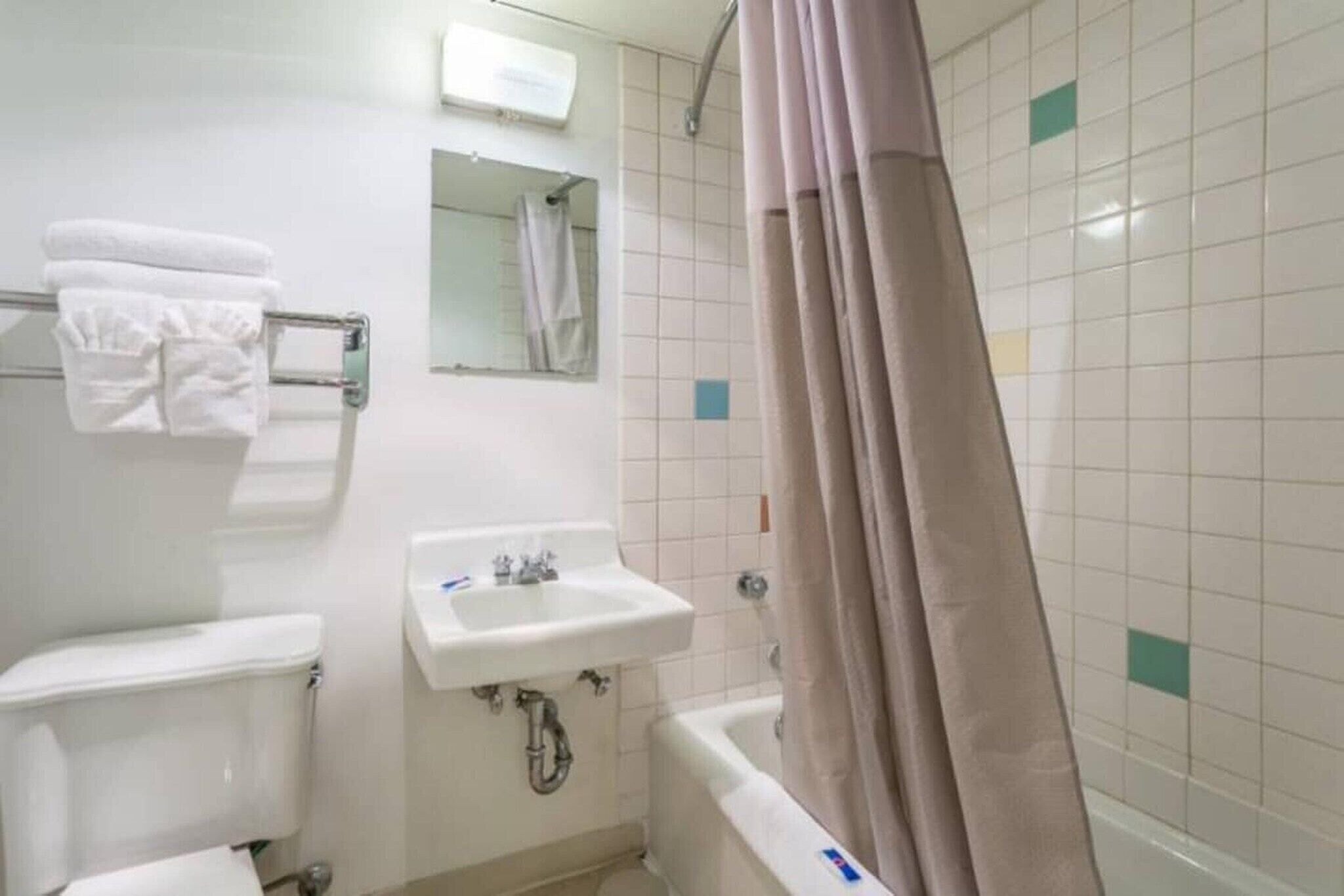 A bathroom with a toilet, sink, and bathtub.