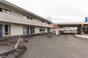A building with a flat facade, multiple windows, and a parking area in front. - 2 Queen Beds | Non-Smoking (Butte)