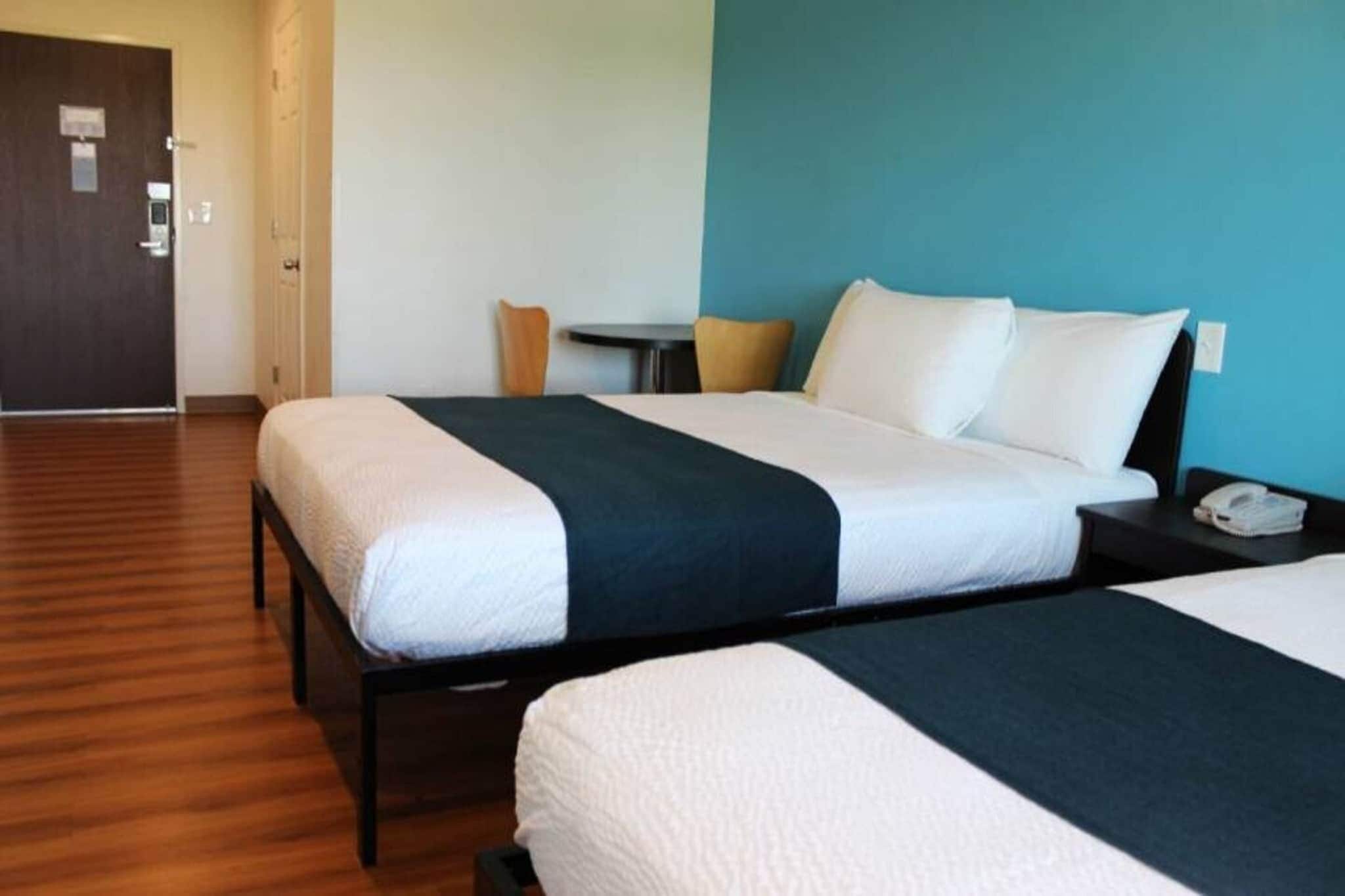 Une chambre d’hôtel avec deux lits, une petite table et une chaise.