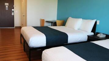 Une chambre d’hôtel avec deux lits, une petite table et une chaise.
