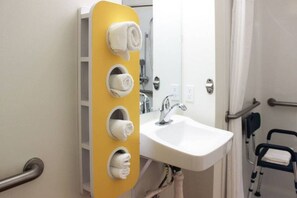 A bathroom with a white sink, a mirror, and a yellow towel rack with four towels. - Cozy 2 Queen Beds|Vending Machine (Rexburg)