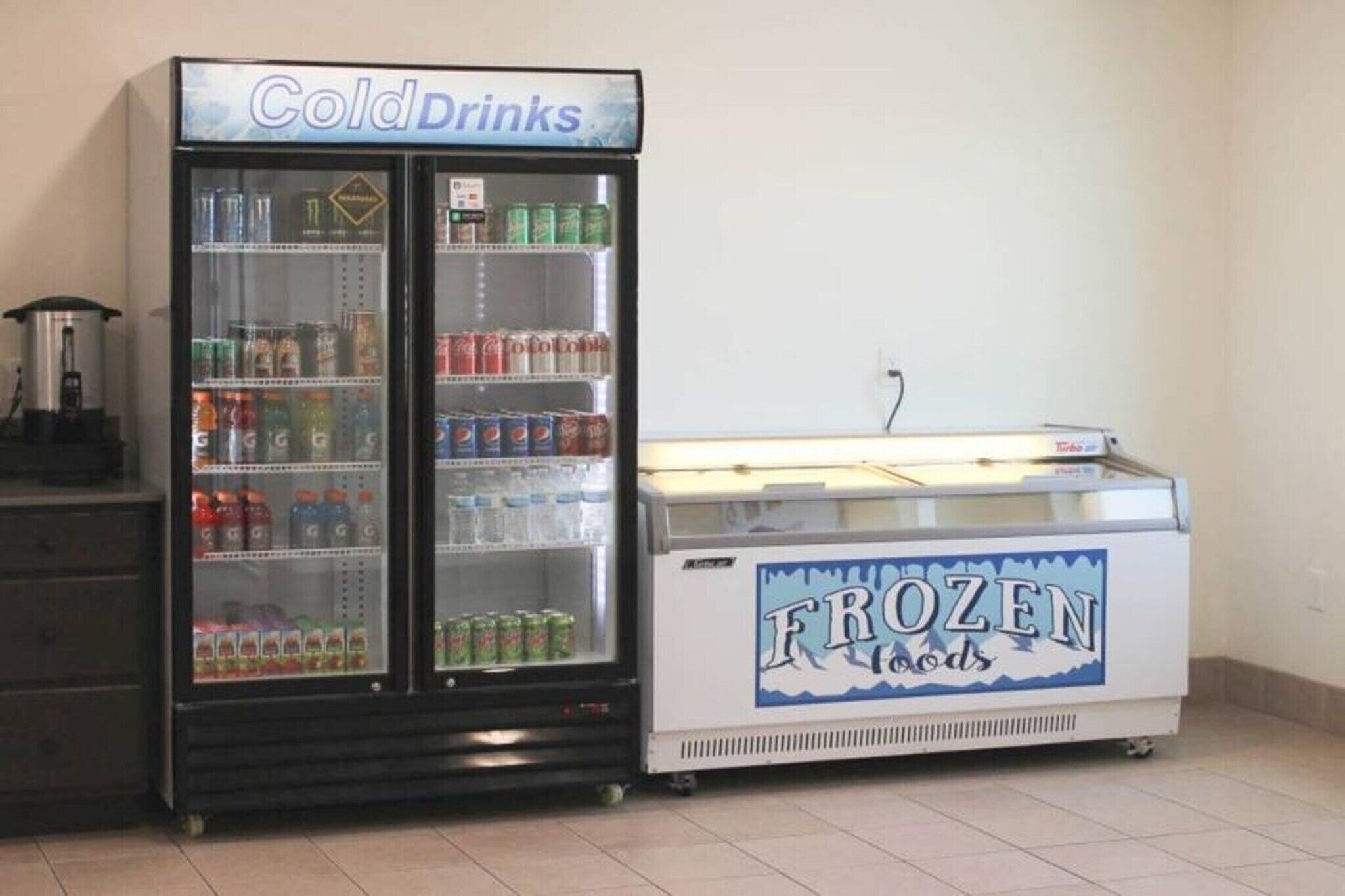 A vending machine with a sign that reads 'Frozen Foods' and another sign above it that says 'Cold Drinks.'