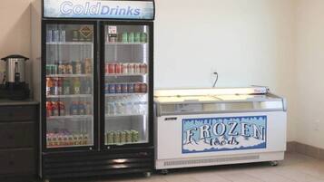 A vending machine with a sign that reads 'Frozen Foods' and another sign above it that says 'Cold Drinks.'