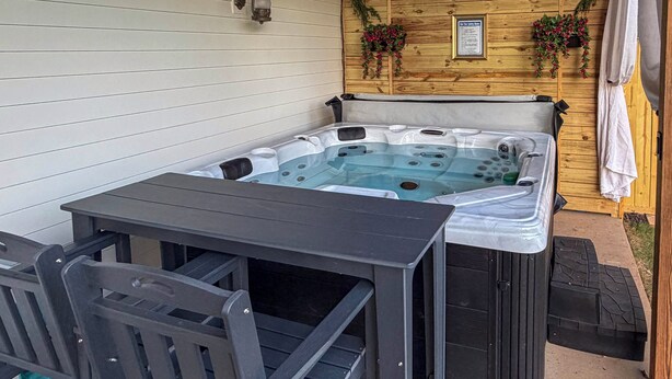 A hot tub with a table and chairs in an outdoor setting. - Hot Tub, Goats, 10 Mins to Sheriff's Jeep Fest! (Dawsonville)