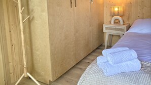 A wooden room with a bed, a nightstand, and a wardrobe. - Refuxio da Carballeira - Cabin 1 (pet-friendly) (Rebordelo (San Martiño))