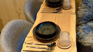 A wooden dining table with a set of cutlery and a glass. - Refuxio da Carballeira - Cabin 1 (pet-friendly) (Rebordelo (San Martiño))