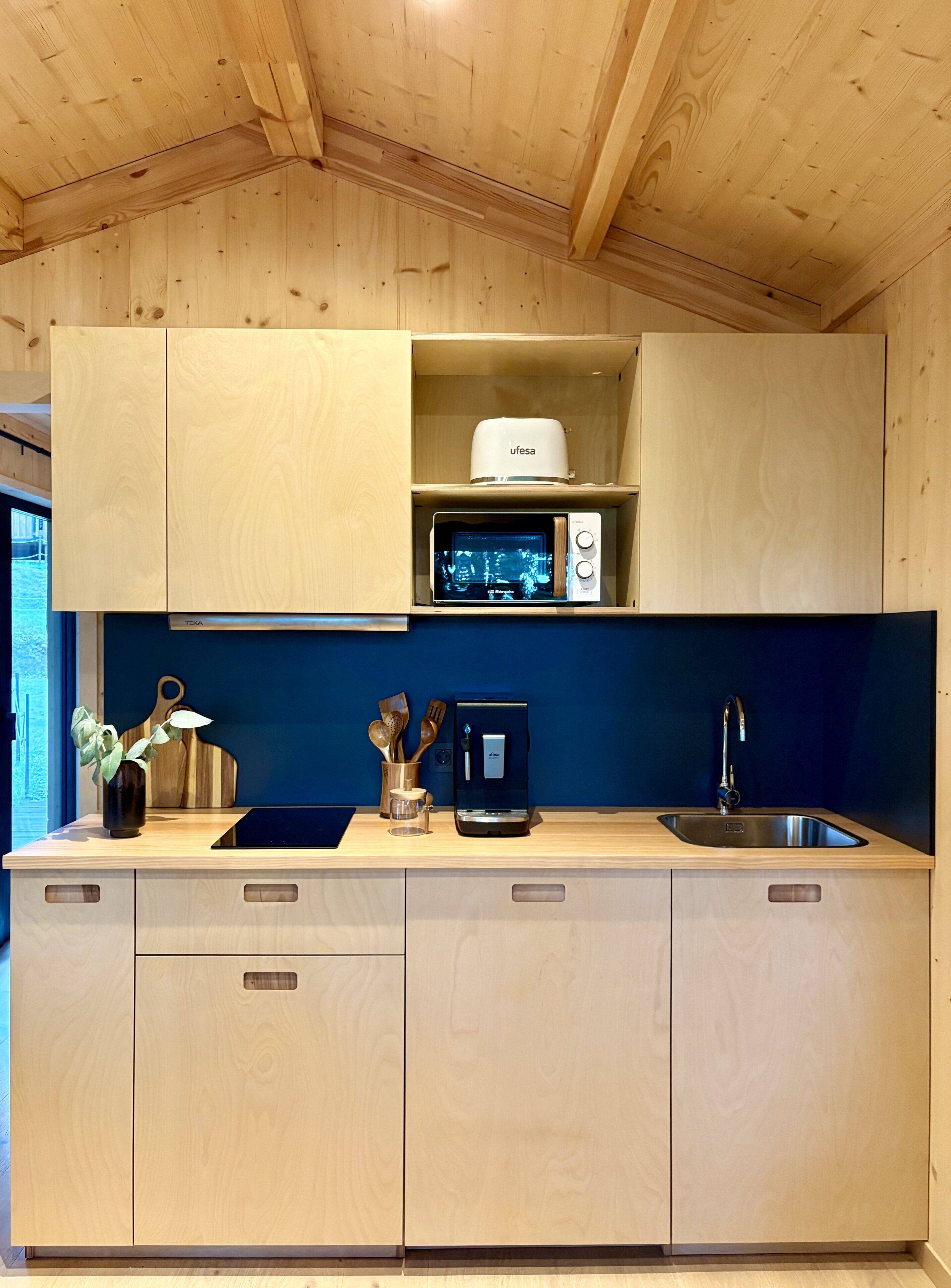 A kitchen with wooden cabinets, a microwave, a toaster, and a sink.
