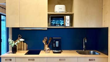 A kitchen with wooden cabinets, a microwave, a toaster, and a sink.