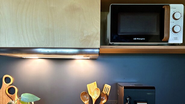 A kitchen with a microwave, a coffee machine, wooden utensils, and a plant. - Refuxio da Carballeira - Cabin 2 (ideal for couples) (Rebordelo (San Martiño))