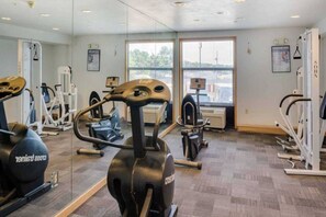A gym with various exercise equipment, large windows, and a view of the outside. - 1 KING BED | SUITE, NON-SMOKING, HOT TUB (Richmond IN)