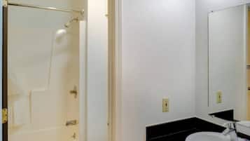 A bathroom with a bathtub, a sink, and a mirror.