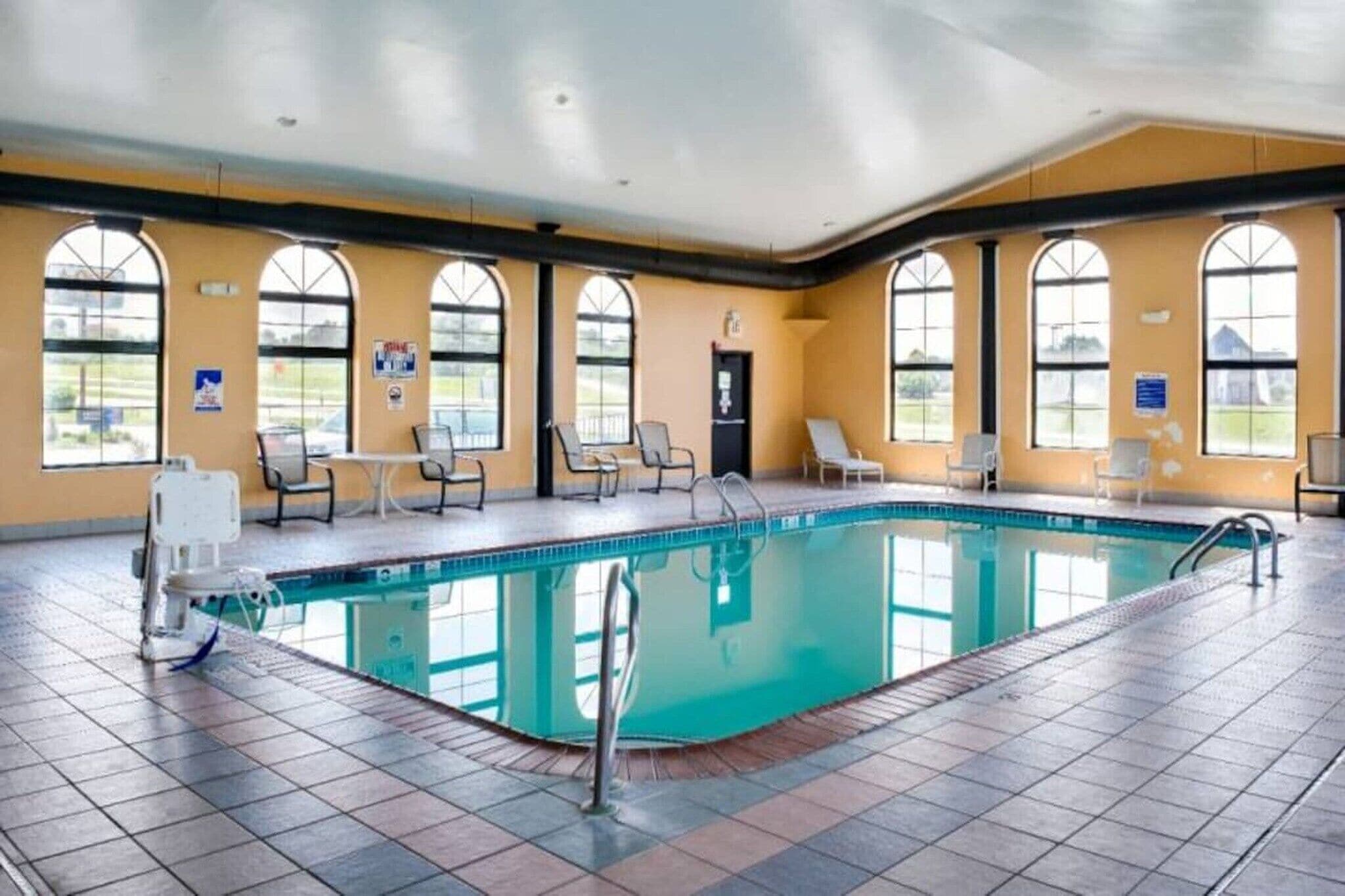 Ein großes Hallenbad mit mehreren Liegestühlen und einem Umkleideraum.
