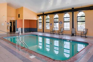 A swimming pool with a tiled deck, a lifeguard chair, and a seating area with tables and chairs. - 2 Queen Beds | Non-Smoking (Richmond IN)