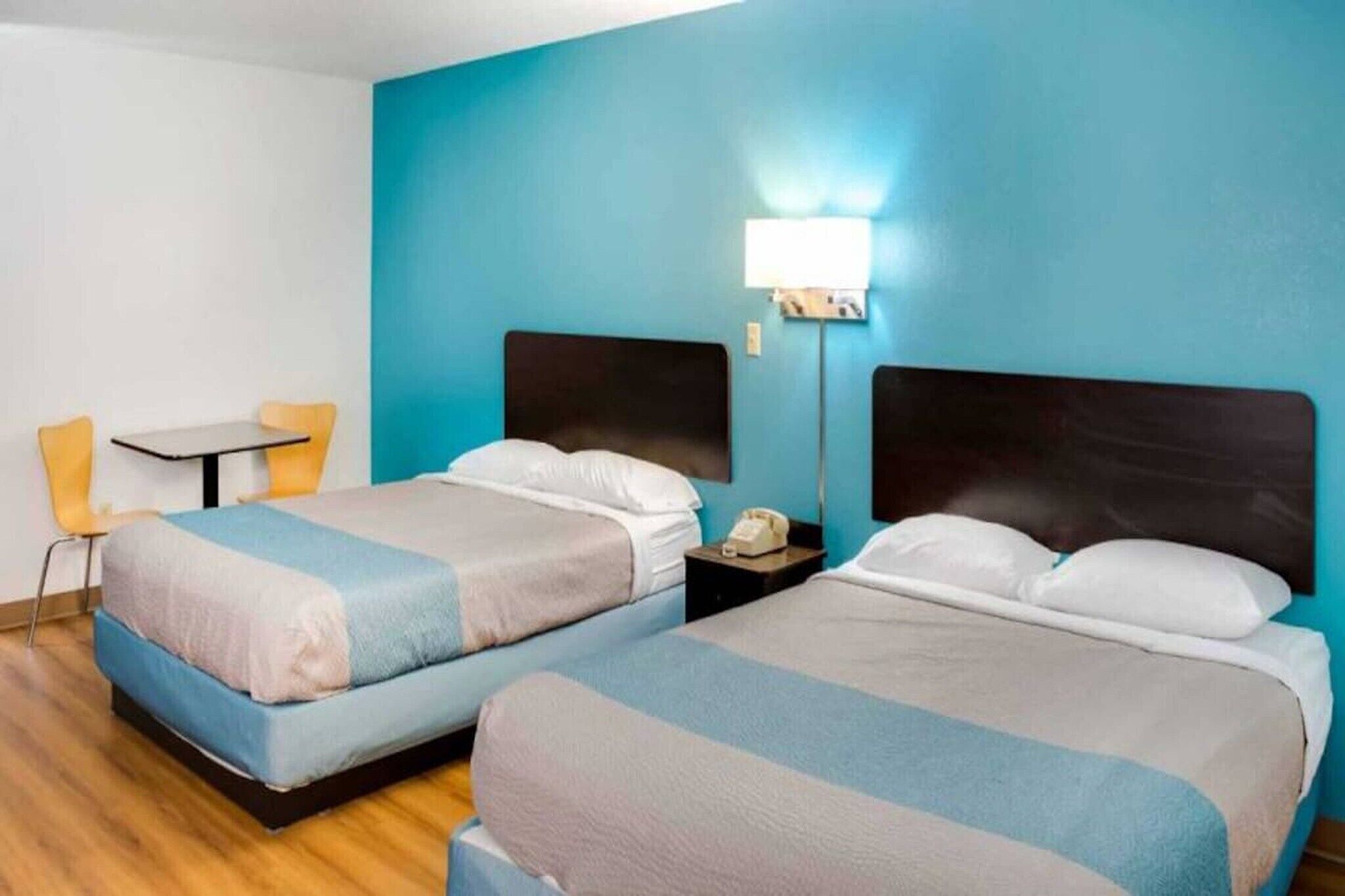 Una habitación de hotel con dos camas, un escritorio y una silla.