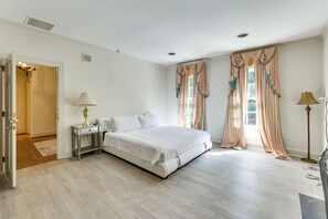 A bedroom with a bed, bedside tables, a lamp, curtains, and a view of the outdoors. - 3 Mi to Dtwn! Grand Goldsboro Getaway (Goldsboro)