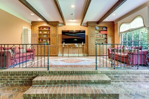 A spacious living area with a fireplace, a television, and a large window overlooking greenery. - 3 Mi to Dtwn! Grand Goldsboro Getaway (Goldsboro)
